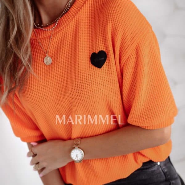 Oranžový sveter s krátkymi rukávmi.
