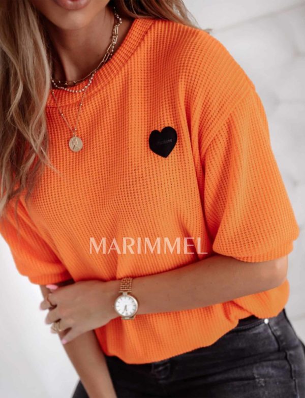 Oranžový sveter s krátkymi rukávmi.