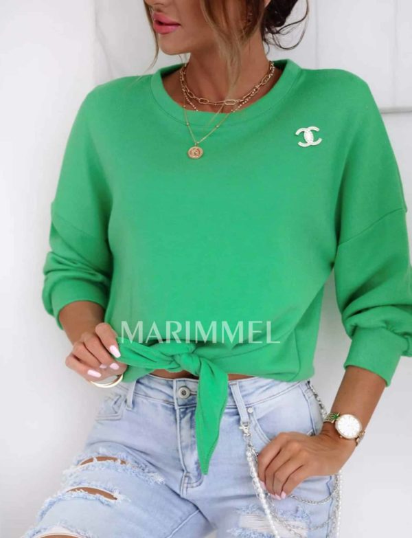 Zelený sveter s brošňou a zaväzovaním.